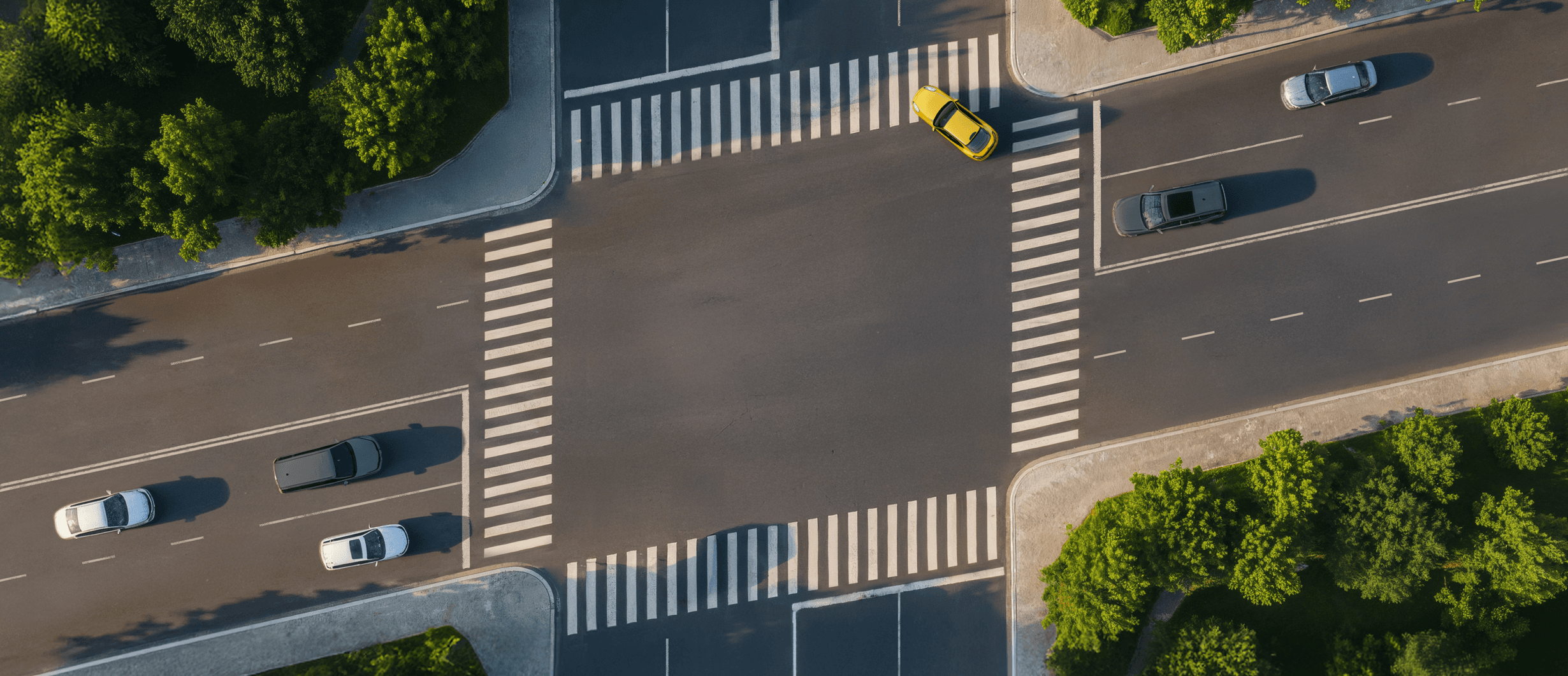 Aerial view of a street intersection where the crosswalks form a slanted parallelogram, imitating the Stripe logo.